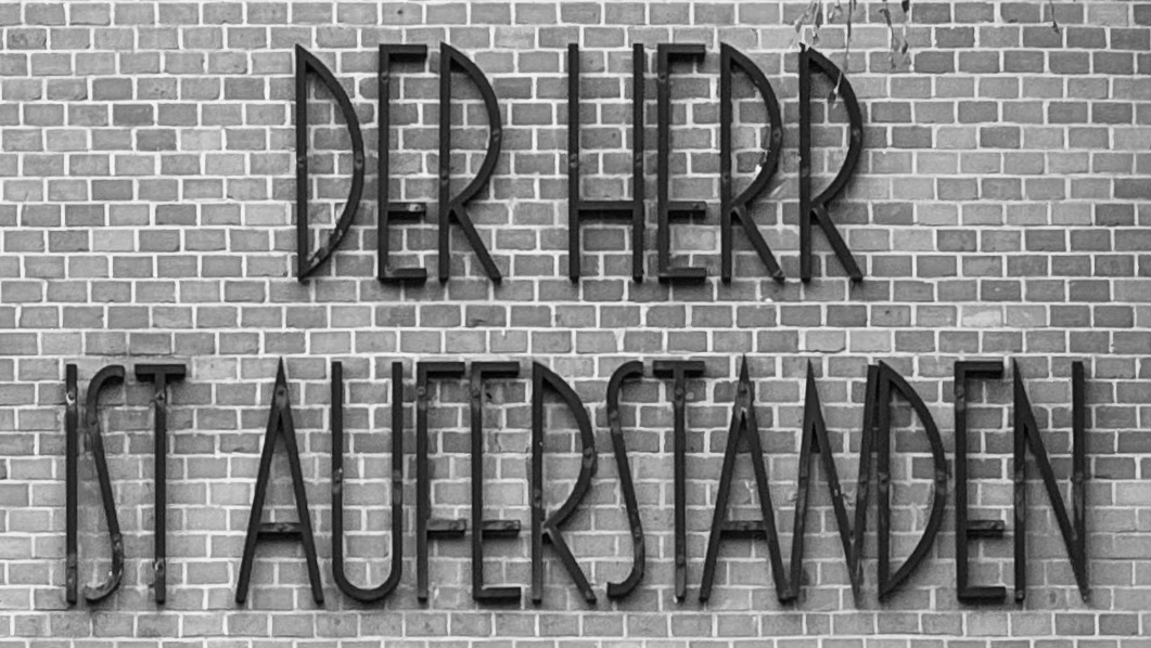 Schriftzug an einem Berliner Friedhof: Der Herr ist auferstanden, aber in Caps.